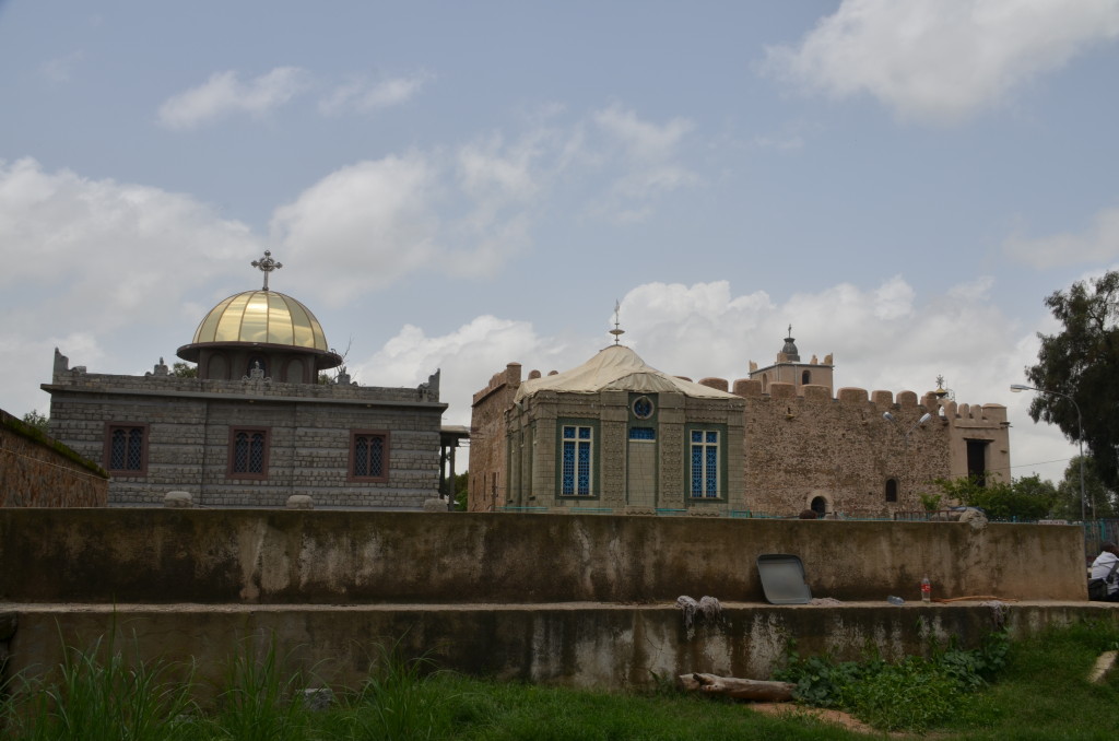 Darrera l'edifici construit per Haile Selassie hi ha els edificis històrics, dels quals el de pedra és el més antic que es conserva, construit pel rei Fasiledes (el que va fer els castells de Gondar) i el de l'esquerra és on suposadament s'allotja l'Arca de l'Aliança. Les dones no podem acostar-nos més enllà del petit mur