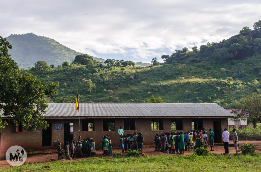 Els alumnes formen davant de l'escola abans de començar les classes per cantar l'himne ugandès